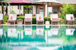 a group of chairs and umbrellas next to a swimming pool at Villa Ayundra in Lipa Noi