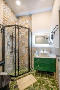 y baño con lavabo verde y ducha. en Apart Hotel Console en Tiflis