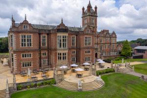 a large brick building with a clock tower at Crewe Hall Hotel & Spa - Cheshire in Crewe