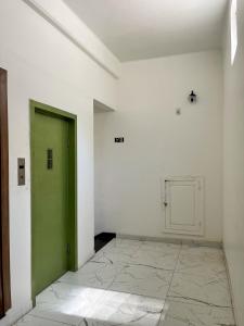 貝倫的住宿－HOTEL AVENIDA，白色客房的绿色门,铺有瓷砖地板
