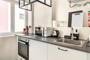 a white kitchen with a sink and a microwave at Prior23 in old town 4min from beach w/ terrace in Cascais