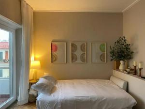 a bedroom with a bed and paintings on the wall at Prior23 in old town 4min from beach w/ terrace in Cascais
