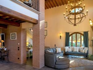 a living room with two couches and a chandelier at Pleasant villa in Peccioli with private swimming pool in Montelopio