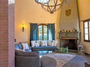 a living room with a couch and a fireplace at Pleasant villa in Peccioli with private swimming pool in Montelopio