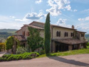 une vieille maison en pierre avec un arbre en face de celle-ci dans l'établissement Beautiful villa in San Giovanni del Pantano with pool, à San Giovanni del Pantano