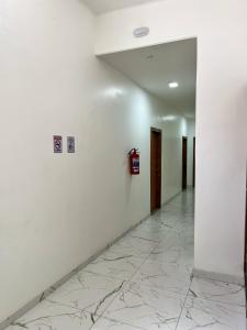 a hallway with white walls and a fire hydrant on a wall at HOTEL AVENIDA in Belém
