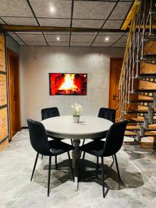 a table and chairs in a room with a fire painting on the wall at BRIVIBAS RESIDENCE - STONES, free PRIVAT parking, free WIFI, self check-in in Rīga