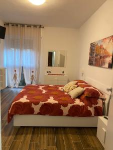 a bedroom with a bed with a comforter at SestoHome26 in Sesto San Giovanni