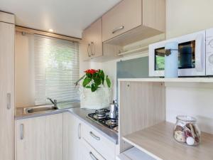 a kitchen with white cabinets and a sink at Modern detached chalet with terrace near the beach in Cesenatico