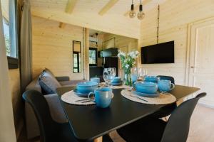 jadalnia ze stołem i niebieskimi daniami w obiekcie Górna Kudowa Domki Wypoczynkowe w Kudowie Zdroju