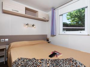 a bedroom with a bed with a window and a windowvisor at Modern detached chalet with terrace near the beach in Cesenatico