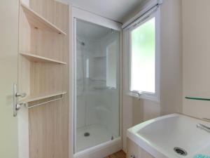 a white bathroom with a shower and a sink at Modern detached chalet with terrace near the beach in Cesenatico