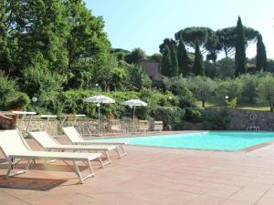 - une piscine bordée de chaises longues et de parasols dans l'établissement Cozy Holiday Home with Pool in Sienna Italy, à Sienne
