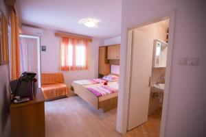 a small room with a bed and a chair at Apartments Dunja Piric in Lopar