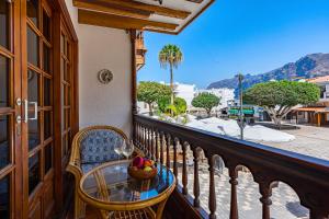 a balcony with a table and a glass of wine at Cozy two bedrooms apartament in the heart of Los Gigantes in Acantilado de los Gigantes
