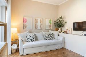 a living room with a white couch and a tv at Prior23 in old town 4min from beach w/ terrace in Cascais