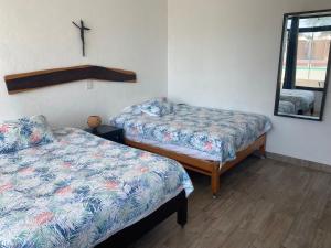 um quarto com duas camas e um espelho em CASA PARAISO em Puerto Morelos