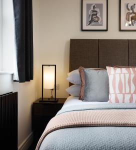 sypialnia z łóżkiem z lampką i poduszkami w obiekcie The Woden Boutique Hotel Walsall M6 J9 w mieście Walsall