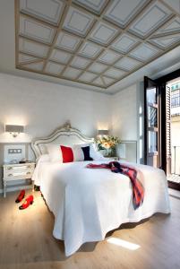 una camera da letto con un grande letto bianco con cuscini rossi di Casa Palacete 1822 a Granada