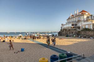 un grupo de personas caminando por la playa en Prior23 in old town 4min from beach w/ terrace en Cascais