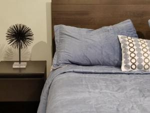 a bed with blue sheets and pillows next to a table at Exquisito y amplio departamento en el mejor sector de Reñaca in Concón