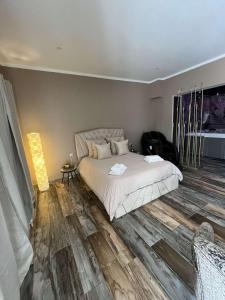 um quarto com uma cama e piso em madeira em Why Not Jacuzzi em Arles