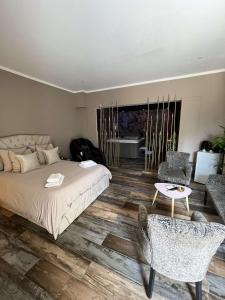 una camera da letto con un letto, un tavolo e delle sedie di Why Not Jacuzzi a Arles