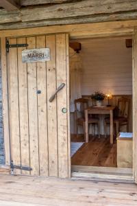 an open door of a wooden cabin with a sign on it at Haanjamehe Taluhotell in Haanja