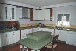 阿莫多瓦德爾里奧的住宿－Casa piscina vista impresionante，厨房配有白色橱柜和绿桌