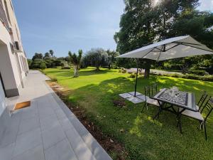 a table with an umbrella in the grass at Villa Persea in Santa Venerina