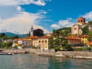 a town by the water with a bridge and buildings at Home in Maccagno con Pino e Veddasca with garden in Maccagno Inferiore