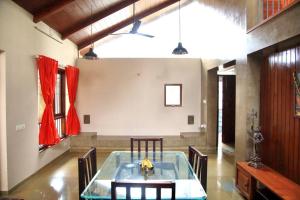 a dining room with a glass table and chairs at RaghavaVijayam in Kolhapur