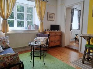 ein Wohnzimmer mit einem Tisch und einem Fenster in der Unterkunft Ferienwohnungen im Lüftlmalereck, Mussldomahaus in Oberammergau