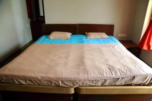 Una cama con dos almohadas encima. en RaghavaVijayam en Kolhapur