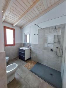 y baño con ducha, aseo y lavamanos. en Villa Campidanese, en Assemini