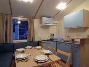 una cocina con una mesa de madera con platos. en Comfortable chalet with two bathrooms at 31 km from Zadar en Biograd na Moru