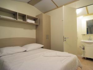 a bedroom with a white bed and a sink at Comfortable chalet with two bathrooms at 31 km from Zadar in Biograd na Moru