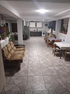 a living room with couches and tables and a kitchen at Lime Hill Hotel in Kutaisi