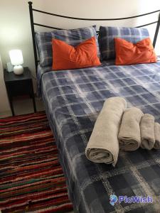 a bed with two pillows and towels on it at Casa Roda in Castiglione del Lago