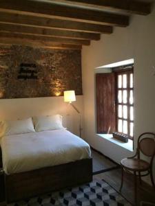 a bedroom with a bed and a window and a lamp at Canela Fina - Adults Only in San Miguel de Allende