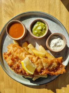 a plate of food with fish and chips and sauce at The Old Mill Inn in Dearham +31 photos
