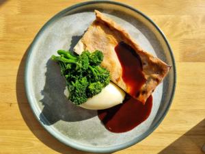 a plate with a piece of food and broccoli on it at The Old Mill Inn in Dearham