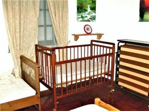 Habitación con 2 cunas, mesa y ventana en Baleal - Large villa near beach up to 12 PAX+2 CH, en Peniche