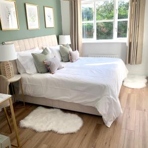 - une chambre dotée d'un grand lit avec des draps et des oreillers blancs dans l'établissement Bright modern flat in central Twickenham, à Twickenham