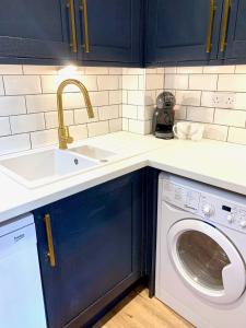 Il comprend une cuisine équipée d'un évier et d'un lave-linge. dans l'établissement Bright modern flat in central Twickenham, à Twickenham