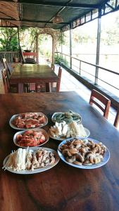 una mesa con muchos platos de comida. en TINA LAKESIDE AO ĐÔI Homestay Phước Hải, en Hội Mỹ