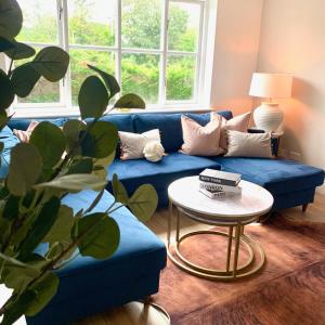 - un salon avec un canapé bleu et une table dans l'établissement Bright modern flat in central Twickenham, à Twickenham