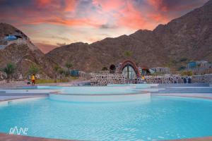 a pool of water in front of a mountain at Dibba Mountain Park Resort in Fujairah