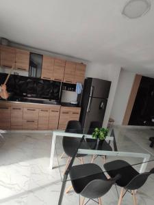 a kitchen with a glass table and black chairs at Hermoso e iluminado apartamento. in Itagüí