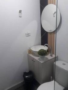 W łazience znajduje się umywalka, toaleta i lustro. w obiekcie Hermoso e iluminado apartamento. w mieście Itagüí